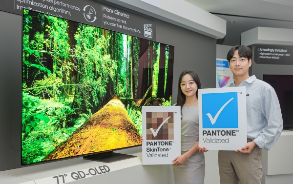 삼성디스플레이 직원들이 TV용 QD-OLED 앞에서 '팬톤 컬러 인증' 및 '팬톤 스킨톤 인증' 로고를 들고 기념 촬영을 하고 있다. [사진=삼성디스플레이]