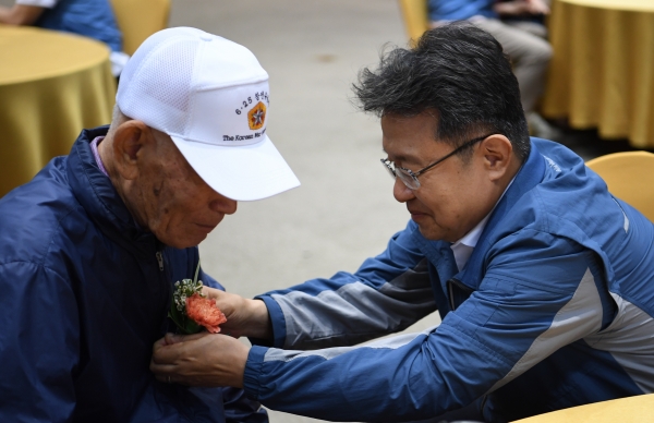 한성희 포스코이앤씨 사장이 6.25 참전 어르신께 꽃을 달아 드리고 있다. [사진제공=포스코이앤씨]