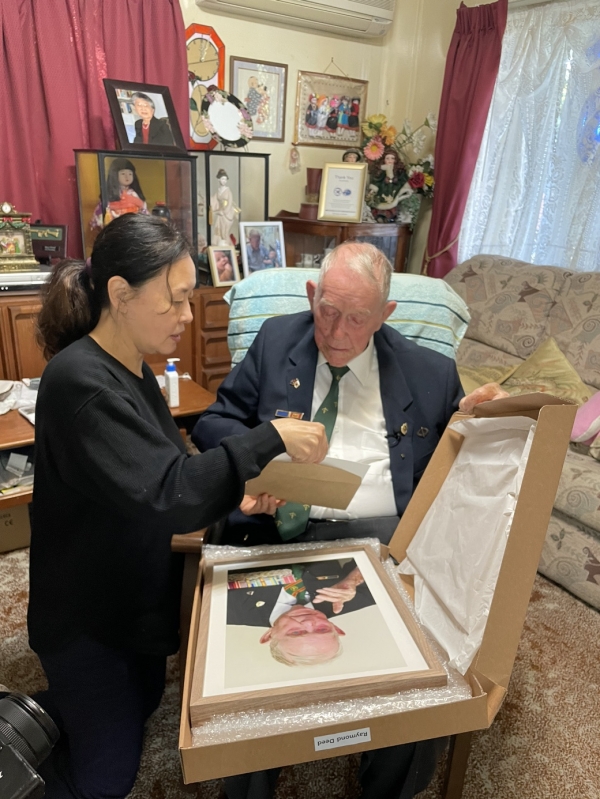 한국전 당시 가평전투에 참전했던 레이먼드 디드(Raymond Deed·96)씨가 호주 브리즈번의 자택에서 사진을 전달 받고 있다. [사진=한화에어로스페이스]