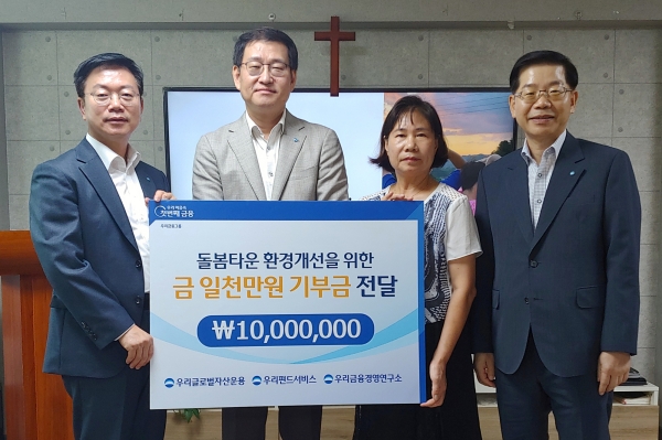 황우곤 우리글로벌자산운용 대표이사, 박정훈 우리금융경영연구소 대표이사, 전경애 돌봄타운 원장, 김정록 우리펀드서비스 대표이사가 돌봄타운 환경개선을 위한  '기부금 전달식'에서 기념 사진을 촬영하고 있다. [사진=우리금융그룹]
