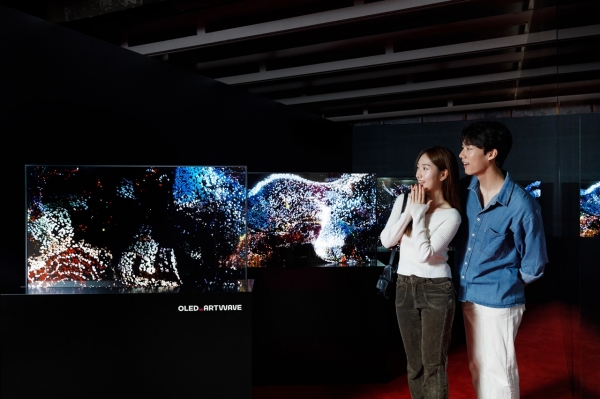 LG디스플레이 모델이 서울 성수동 복합문화공간 '쎈느'에서 열리는 '아트 웨이브' 전시회에서 OLED로 구현한 디지털아트 작품을 관람하고 있다. [사진=LG디스플레이]