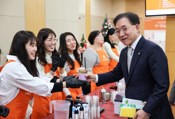 홍정표 한화생명 커뮤니케이션실 부사장이 지난 21일 서울 여의도 63빌딩에서 열린 임직원 봉사단 성과 공유회 ‘V-DAY’에서 바리스타 자격증을 취득한 ‘프로보노 (ProBono)’ 전문 봉사 단원들이 만든 커피를 받고 있다. [사진제공=한화생명]