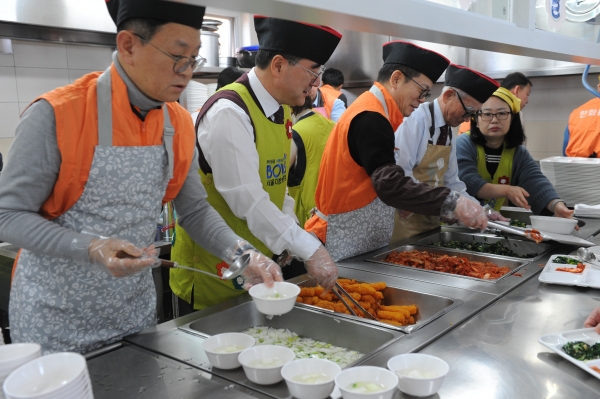 한화시스템 임직원들이 국가유공자들에게 설 음식을 배식하는 모습 [사진=한화시스템]
