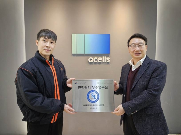한화큐셀 박정필 시스템개발센터장(우)과 정상민 제품개발팀장(좌)이 서울 금천구 시스템개발센터에서 ‘안전관리 우수연구실’ 인증패를 들고 기념 촬영을 하고 있다. [사진=한화큐셀]