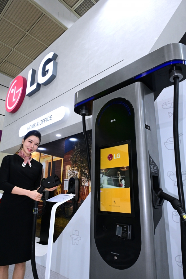 모델이 차량 2대를 동시에 충전할 수 있어 공공 주차장에 유용한 100kW 충전기를 체험하고 있다. [사진=LG전자]