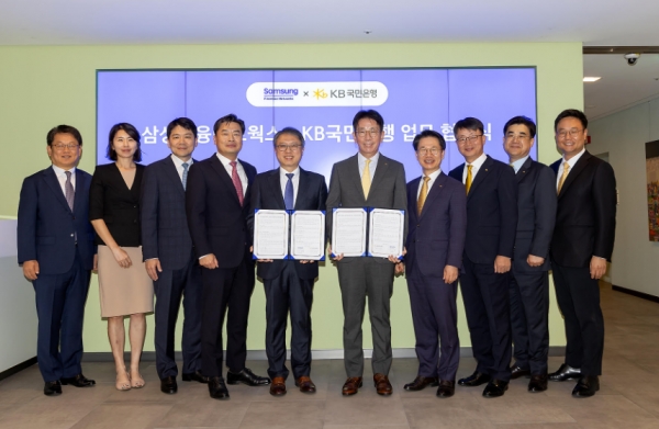 삼성금융네트웍스는 4일 KB국민은행과 서울시 중구에 위치한 삼성본관에서 상호 협력을 위한 업무협약을 체결했다. 삼성금융네트웍스를 대표해 김대환 삼성카드 사장(왼쪽 다섯번째)과 이재근 KB국민은행장(왼쪽 여섯번째), 삼성생명·화재·카드·증권 모니모 관련 업무 담당 임원, KB국민은행 관련 임원 등 관계자들이 기념사진을 촬영하고 있다. [사진제공=삼성카드]