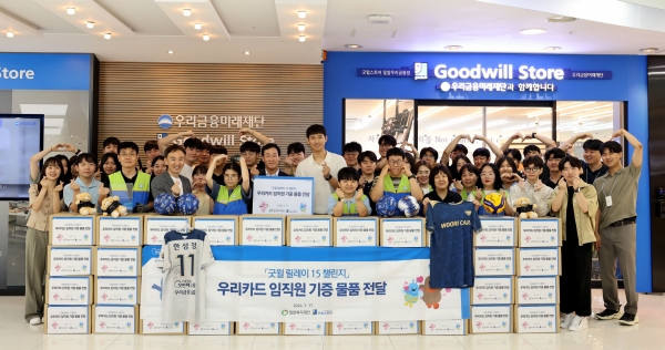 박완식 우리카드 대표이사(가운데 팻말 뒤)를 비롯한 임직원 30명과 우리카드 배구단 한성정 선수(대표이사 우측)가 굿윌스토어에서 기증식 후 기념촬영을 하고 있다. [사진제공=우리카드]