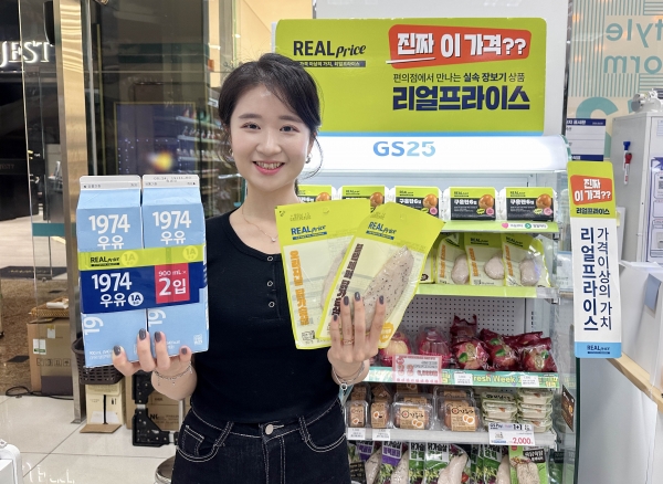 모델이 GS25에서 선보인 가성비 PB 브랜드 리얼프라이스 상품의 고매출 상품을 들고 포즈를 취하고 있다