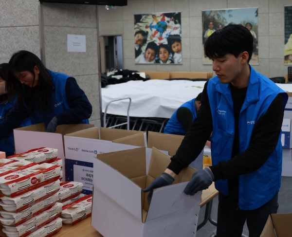 우리카드 임직원 자원봉사단이 꾸러미 상자를 포장하고 있다. [사진제공=우리카드]