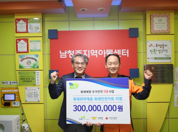 14일 충북 청주시 소재 지역아동센터에서 김용운 LH 총무처장(왼쪽)과 홍영근 소방청 화재예방국장(오른쪽)이 화재예방 주거안전119 사업 관련 기념촬영을 하고 있다.