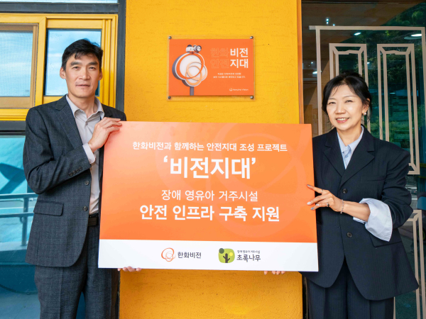 초록나무 비전지대 현판 앞에서 김현섭 한화비전 경영지원실장(왼쪽)과 조애리 초록나무 원장(오른쪽)이 기념 촬영을 하고 있다. [사진=한화비전]