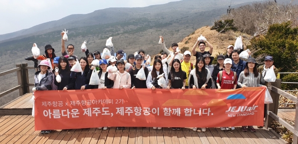 20일 제주항공 임직원들과 제주항공 아카데미 2기 학생들이 한라산 사라오름 전망대에서 수거한 쓰레기를 들고 기념촬영을 하고 있다 [사진=제주항공]