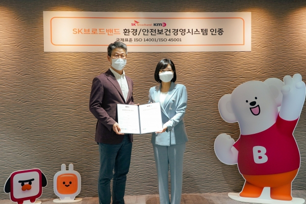 최진환 SK브로드밴드 사장(왼쪽)이 황은주 한국경영인증원 원장으로부터 ISO14001(환경경영시스템)과 ISO45001(안전보건경영시스템) 인증서를 받고 있다.
